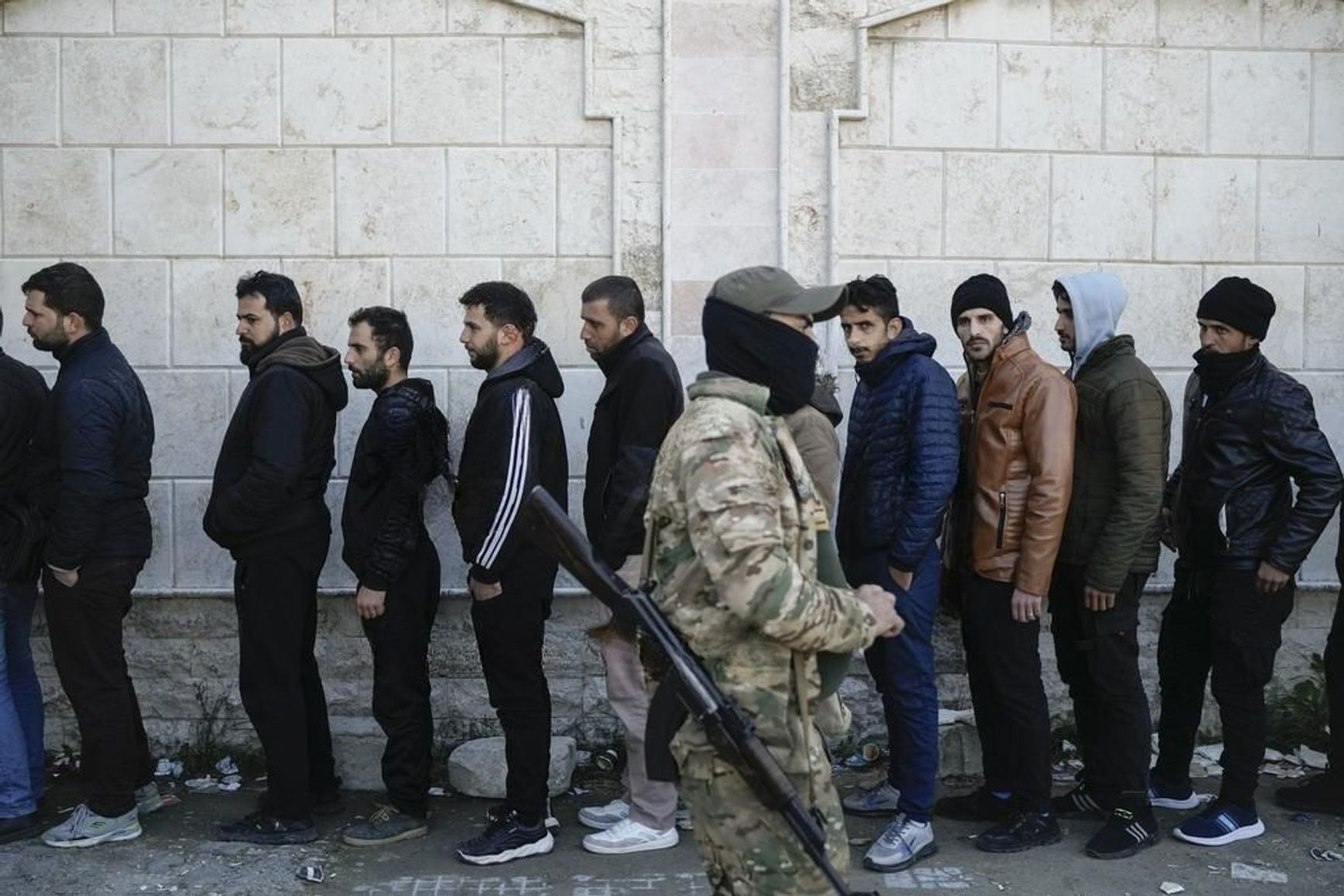 Former soldiers of the Assad regime's army queue for registration at one of the reconciliation points in Latakia.